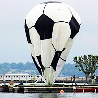 Рабочие надувают футбольный мяч на Женевском озере (Швейцария)